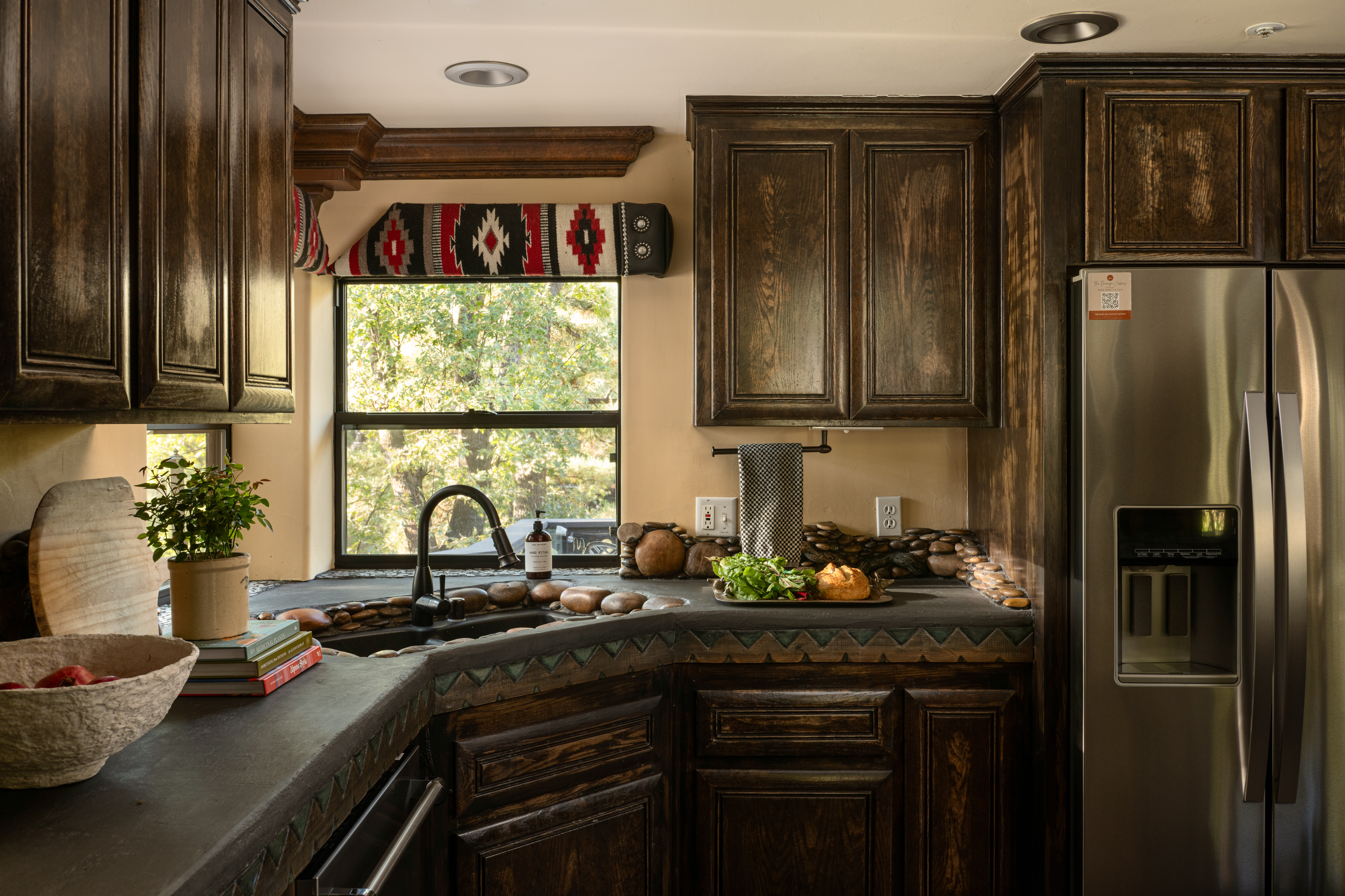 Rustic upscale kitchen with dark wood cabinetry and sunny window views
