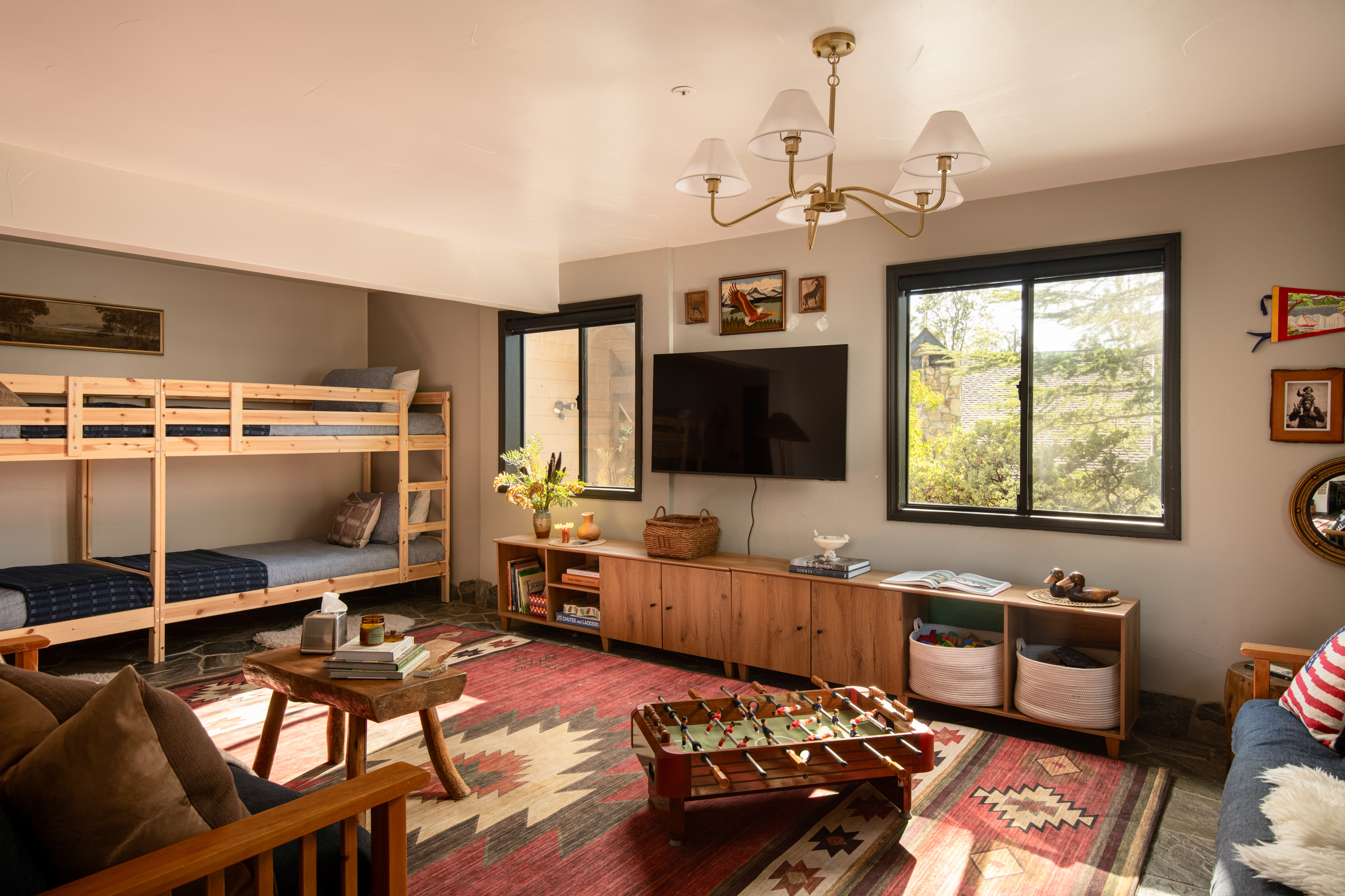 Sunny family lounge with bunk beds, TV, foosball, and cozy rustic style