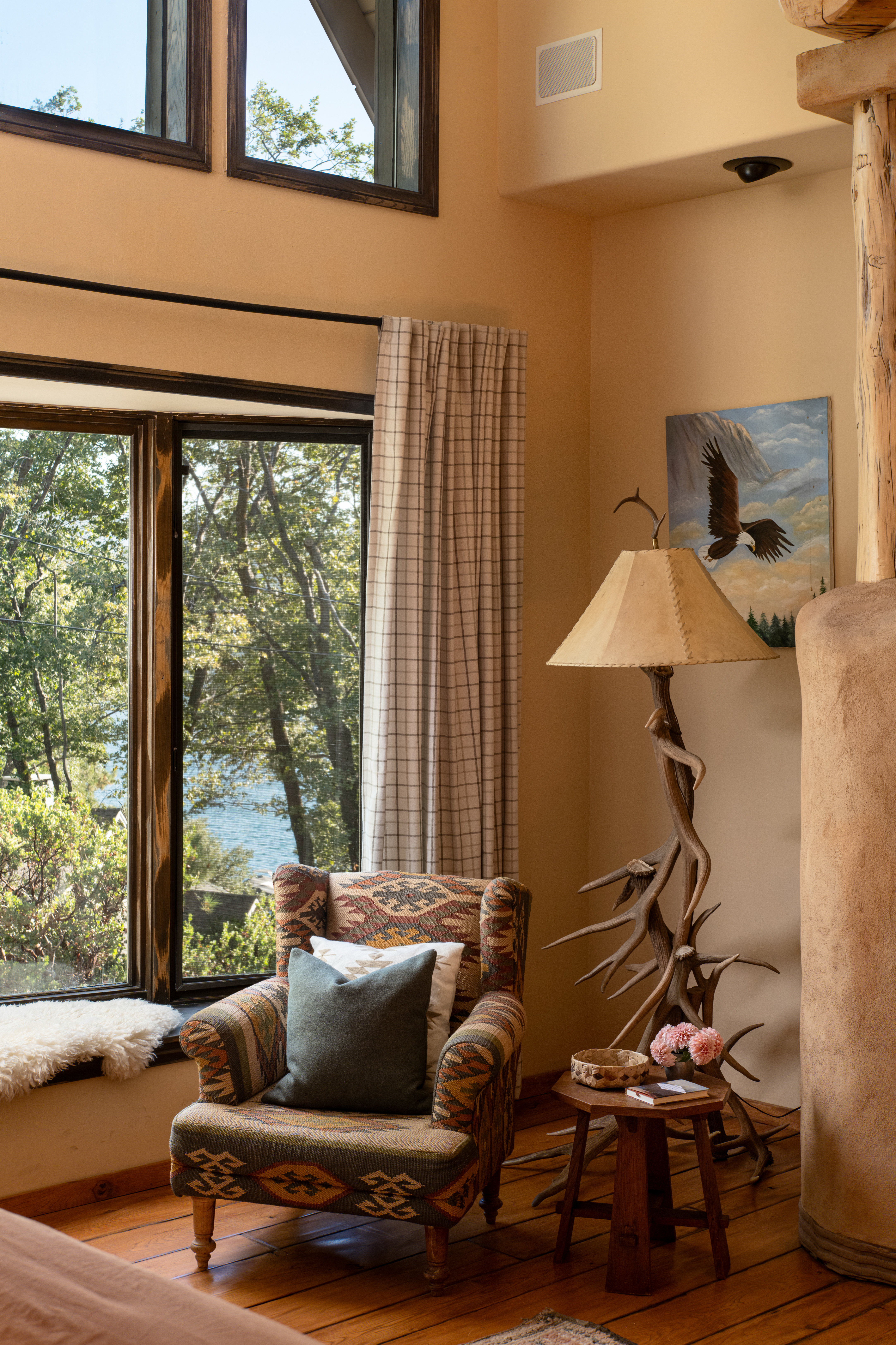 Cozy lodge-style reading nook with soaring windows and tranquil nature views