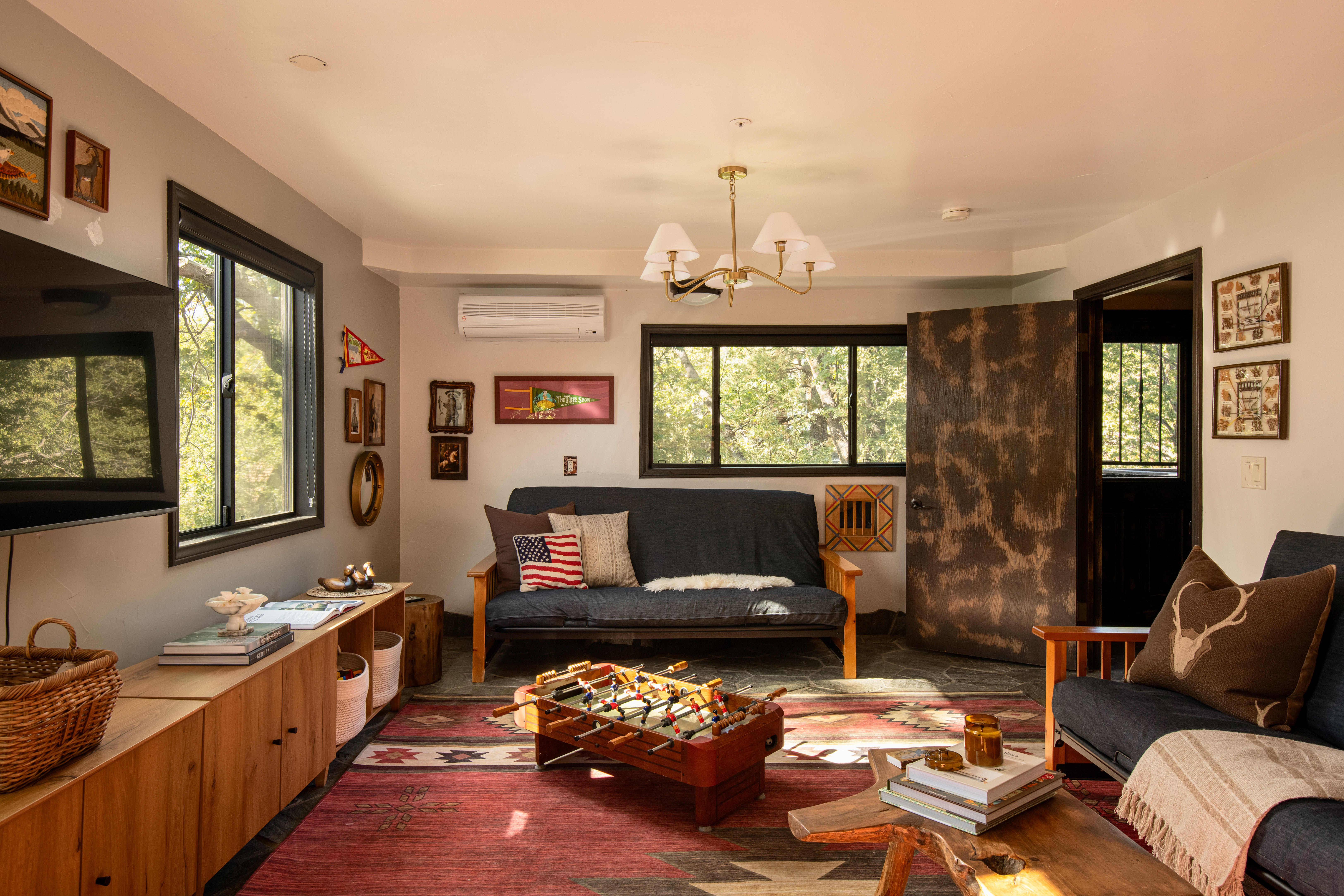 Cozy rustic lounge with forest views and a fun foosball coffee table