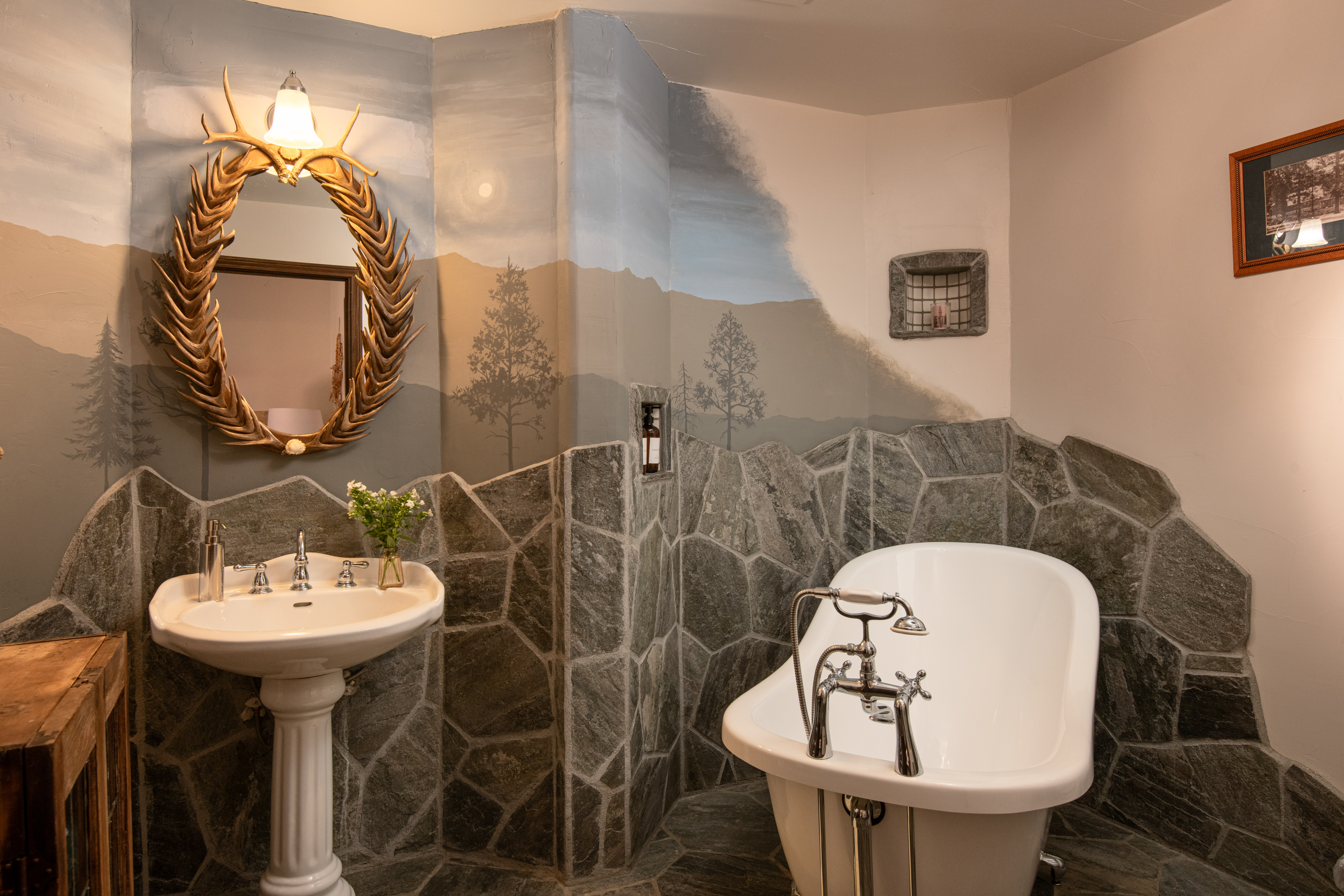 Rustic spa-style bath with clawfoot tub and mountain-inspired design