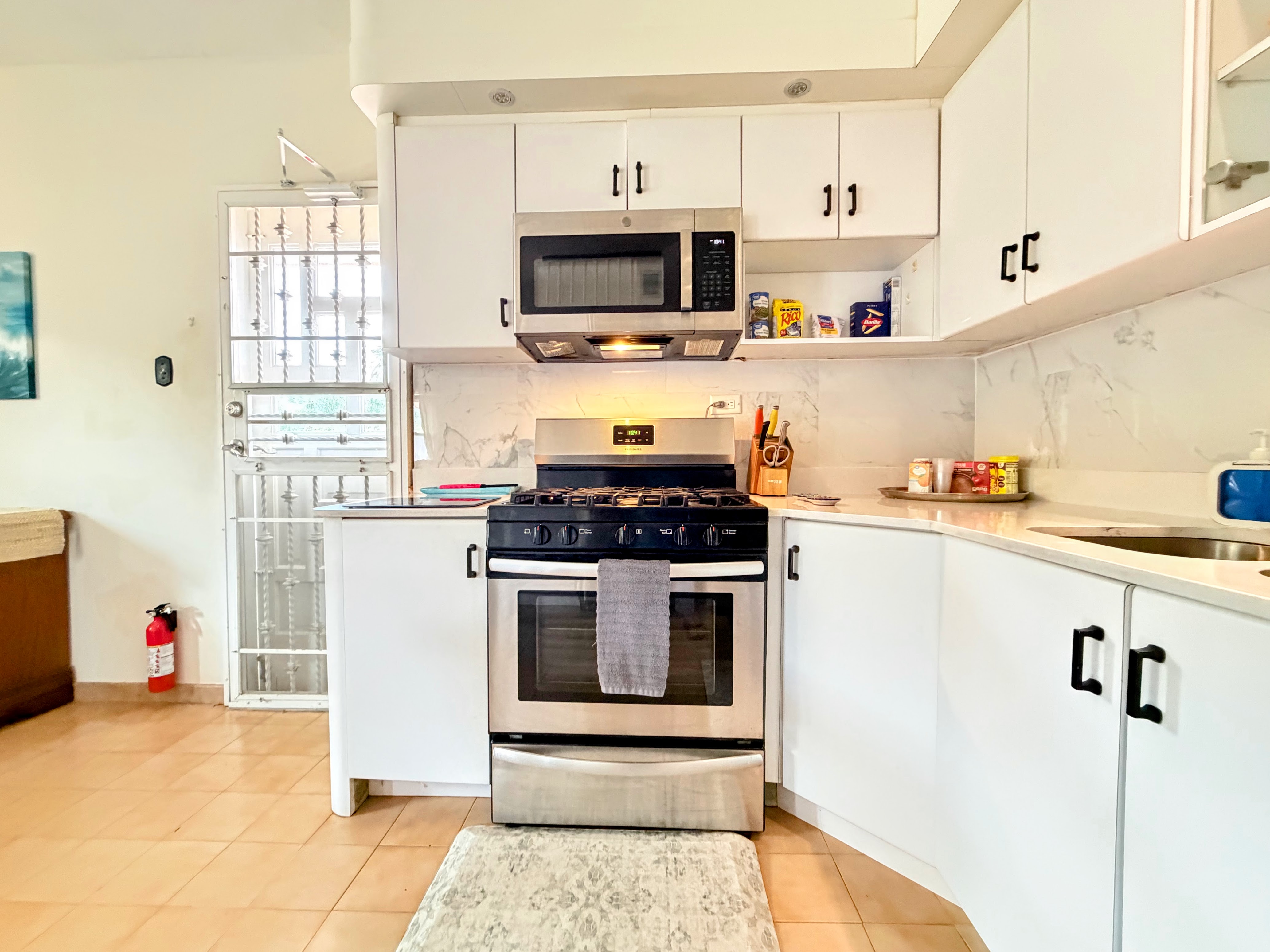 Bright modern kitchen with gas range, sleek finishes, and ample counter space