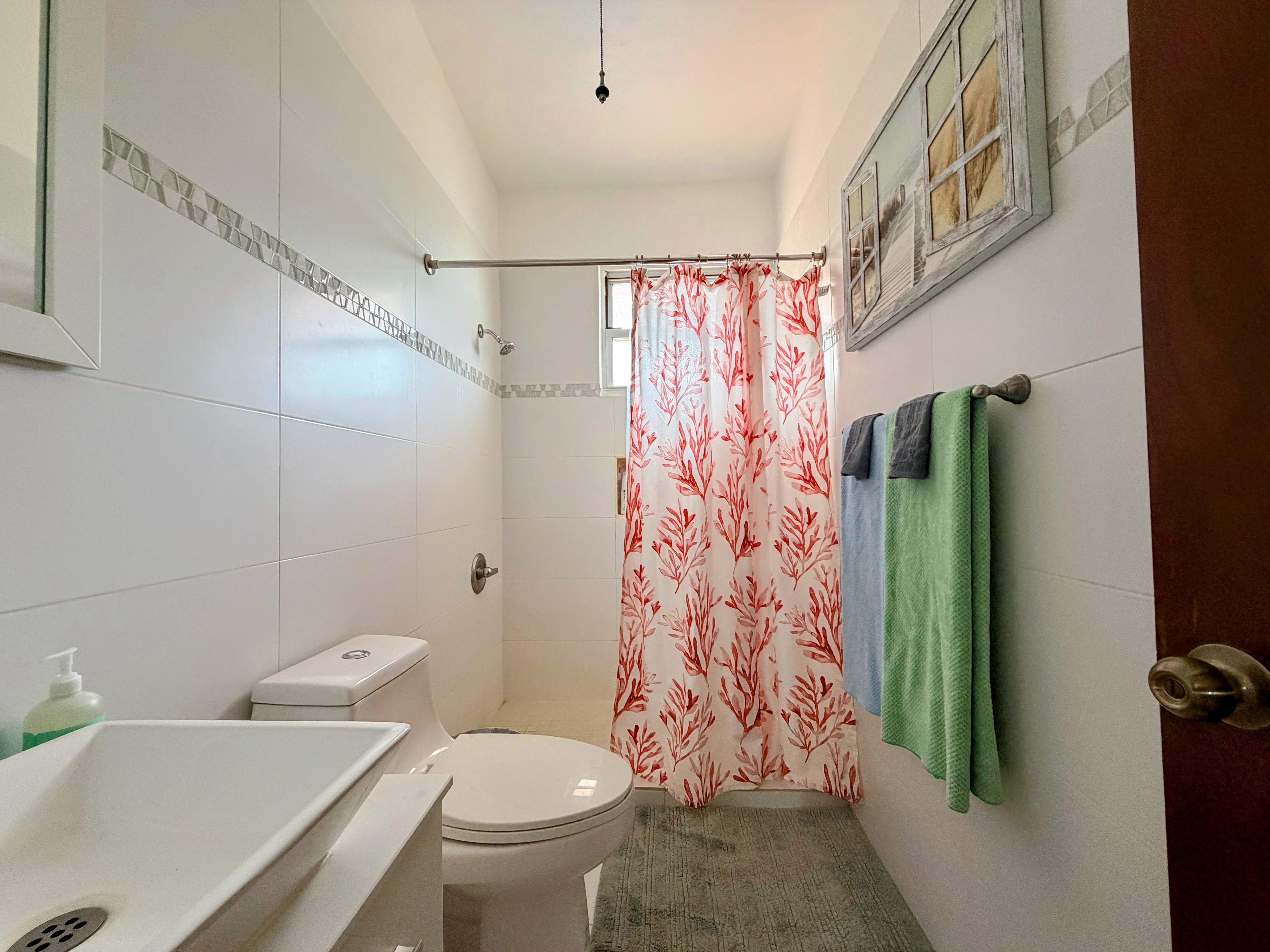 Bright modern bathroom with walk-in shower and cheerful coastal accents