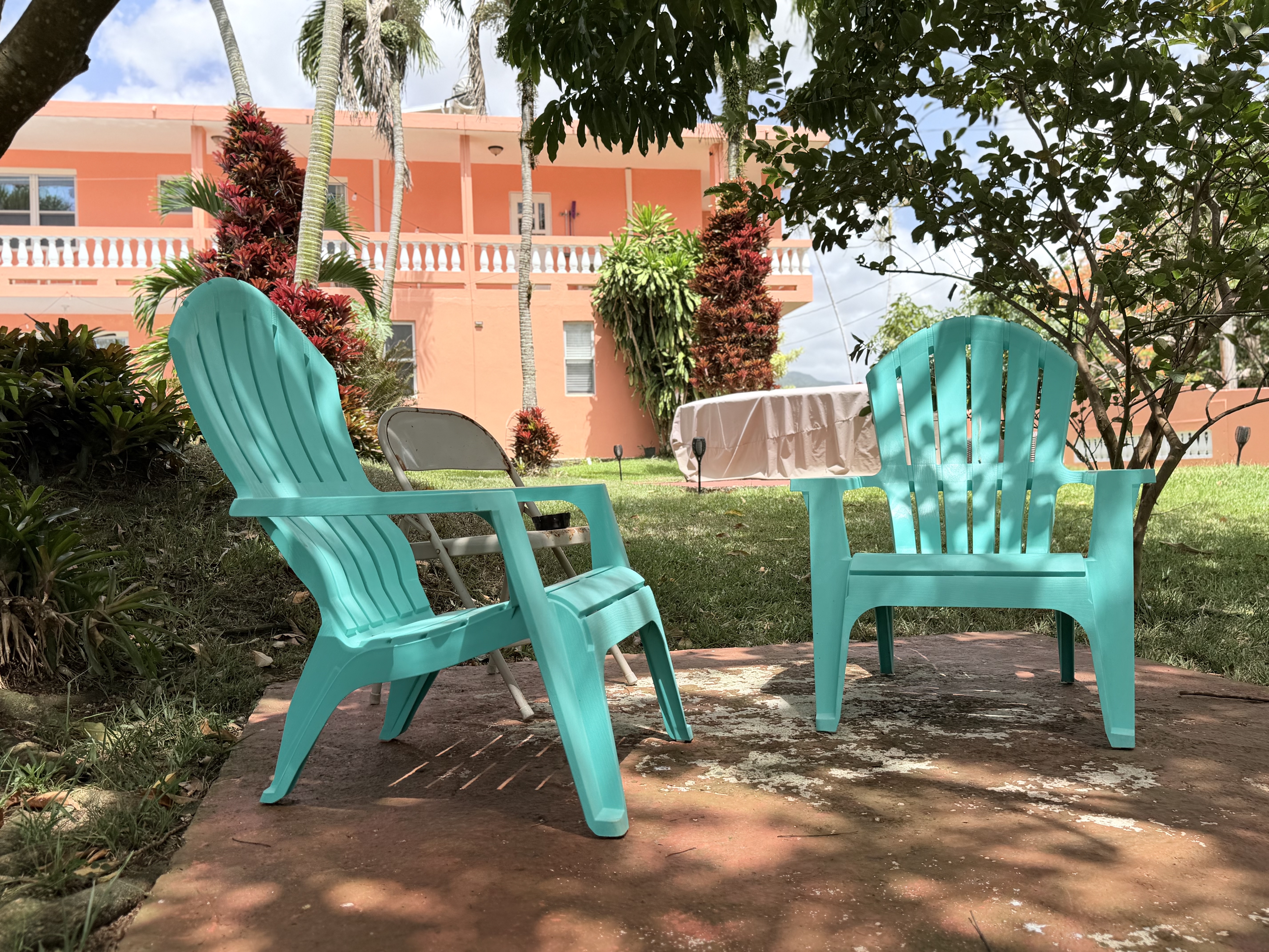 Shaded garden patio with tropical landscaping and cozy outdoor seating