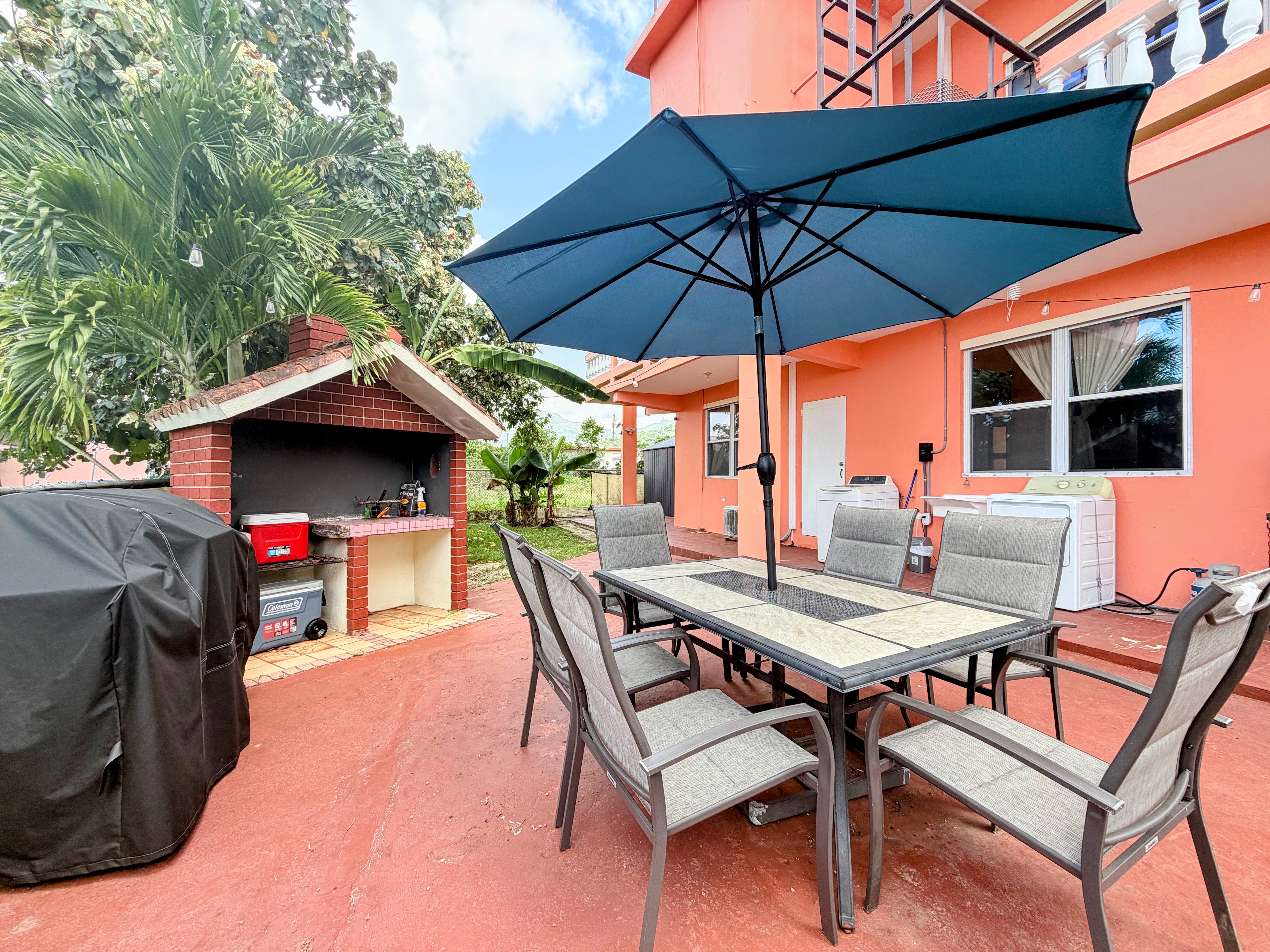 Spacious patio with shaded dining and built-in BBQ grill area