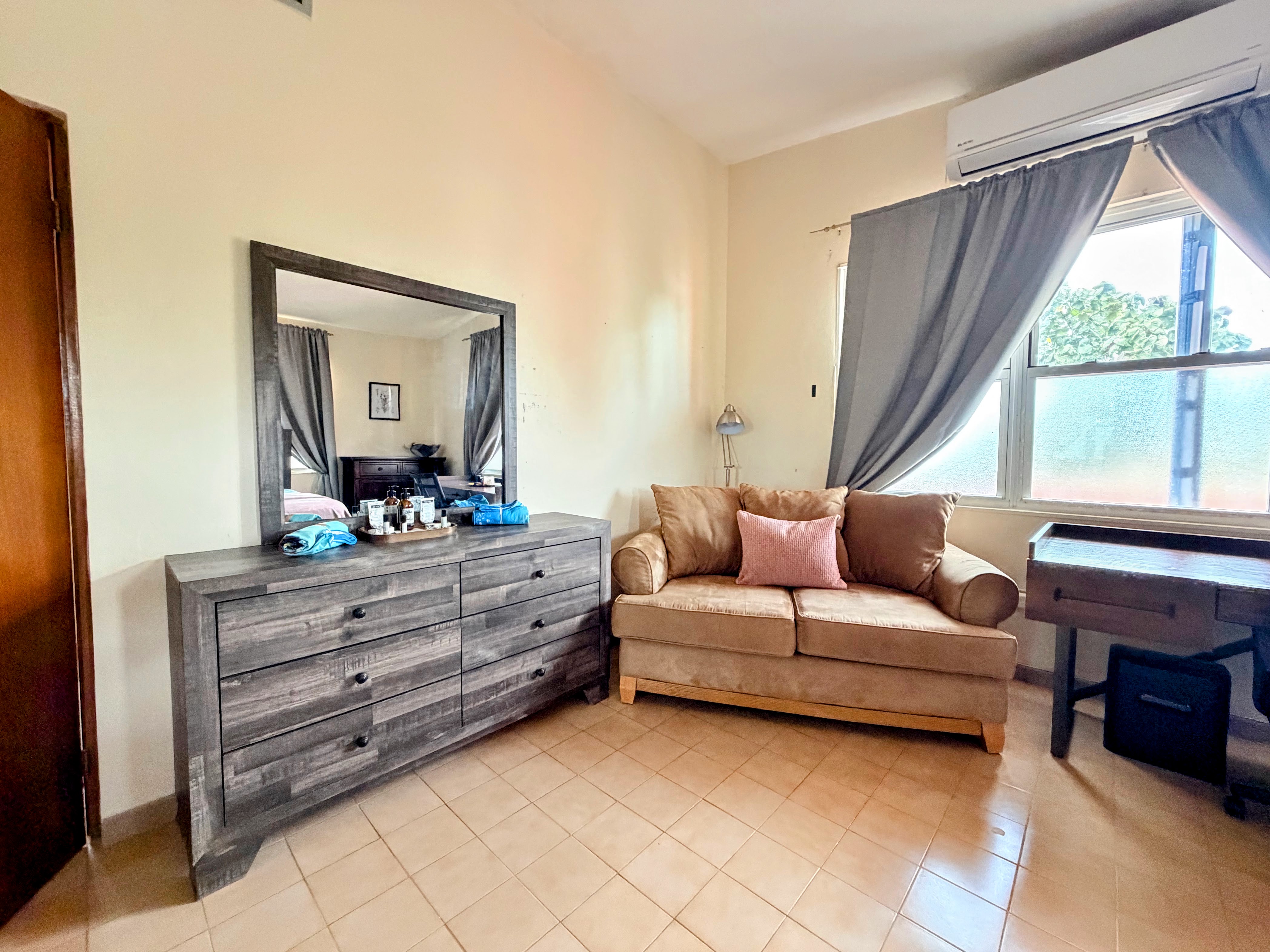 Bright, spacious room with loveseat, desk, and natural light