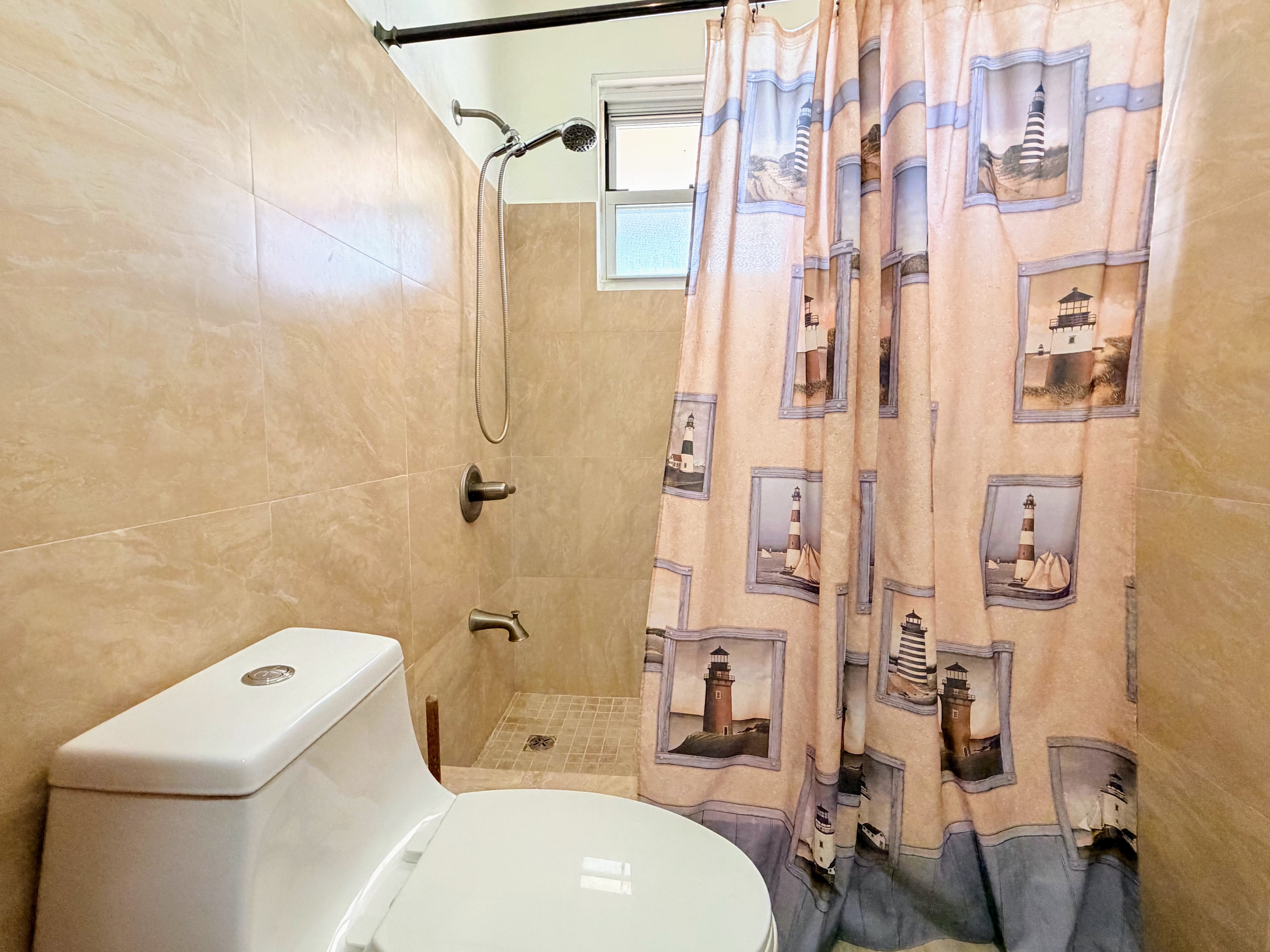 Bright tiled bathroom with walk-in shower and charming coastal decor