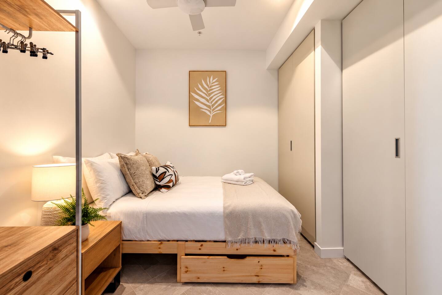 Compact, cozy bedroom w/ tidy bed & minimalist styling.