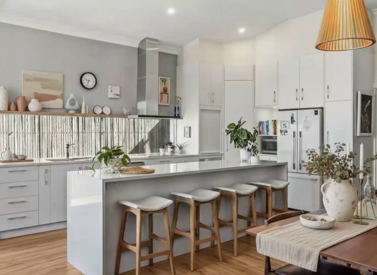 Bright modern kitchen with long island bench and bar stools
