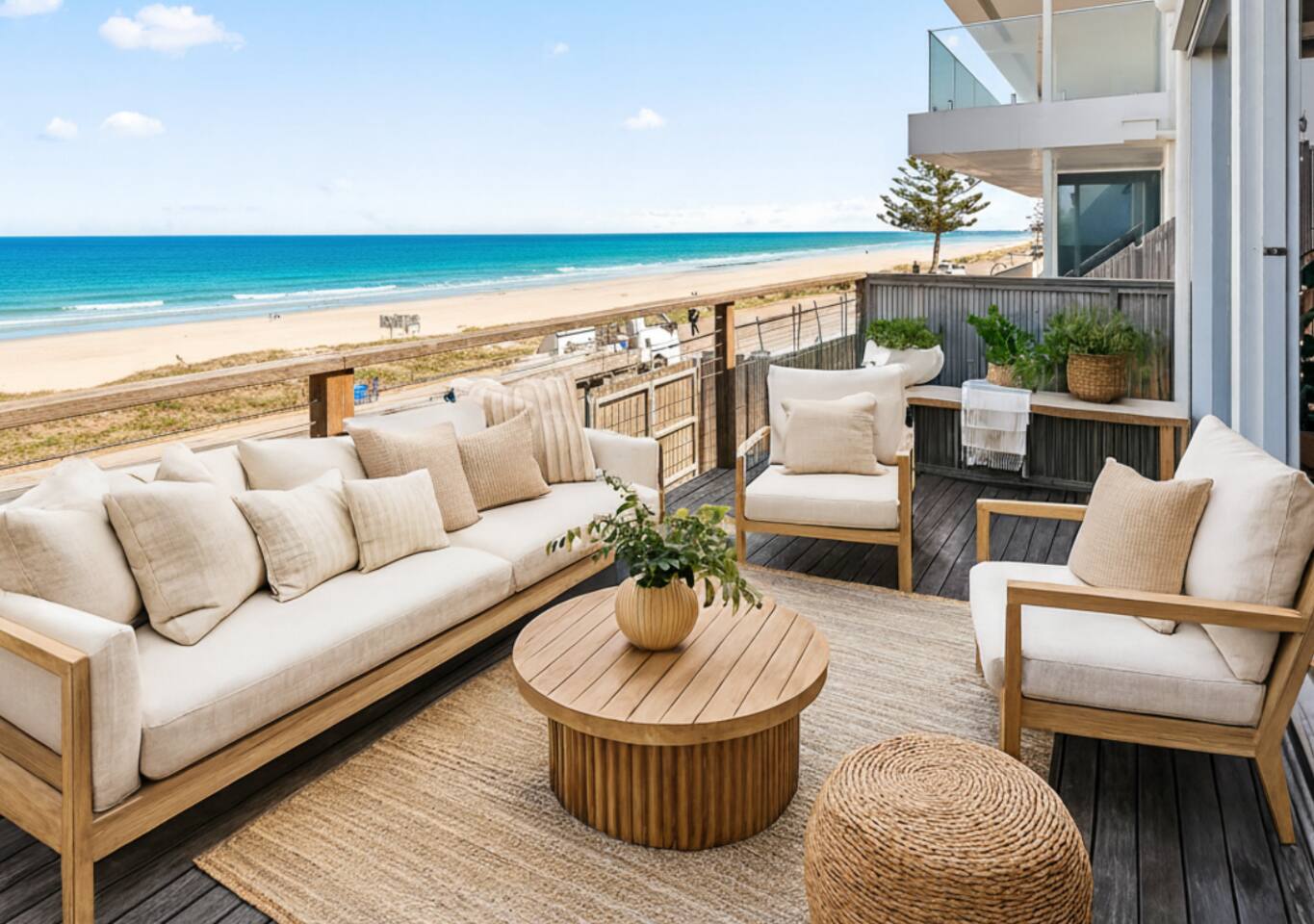 Cushioned outdoor sofas with the beach and ocean stretching ahead