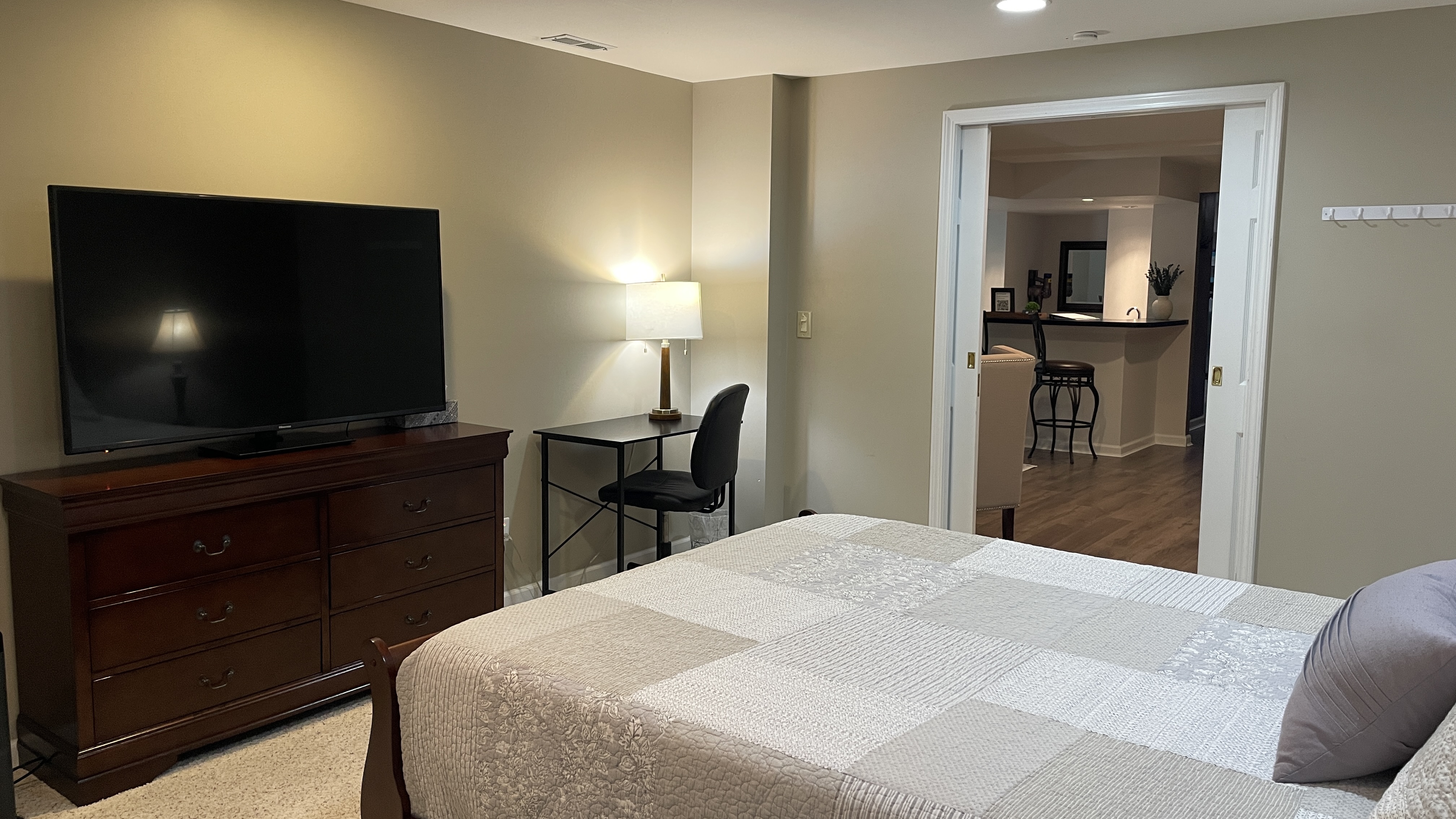 Cozy bedroom with TV, workspace, and easy access to adjoining living area