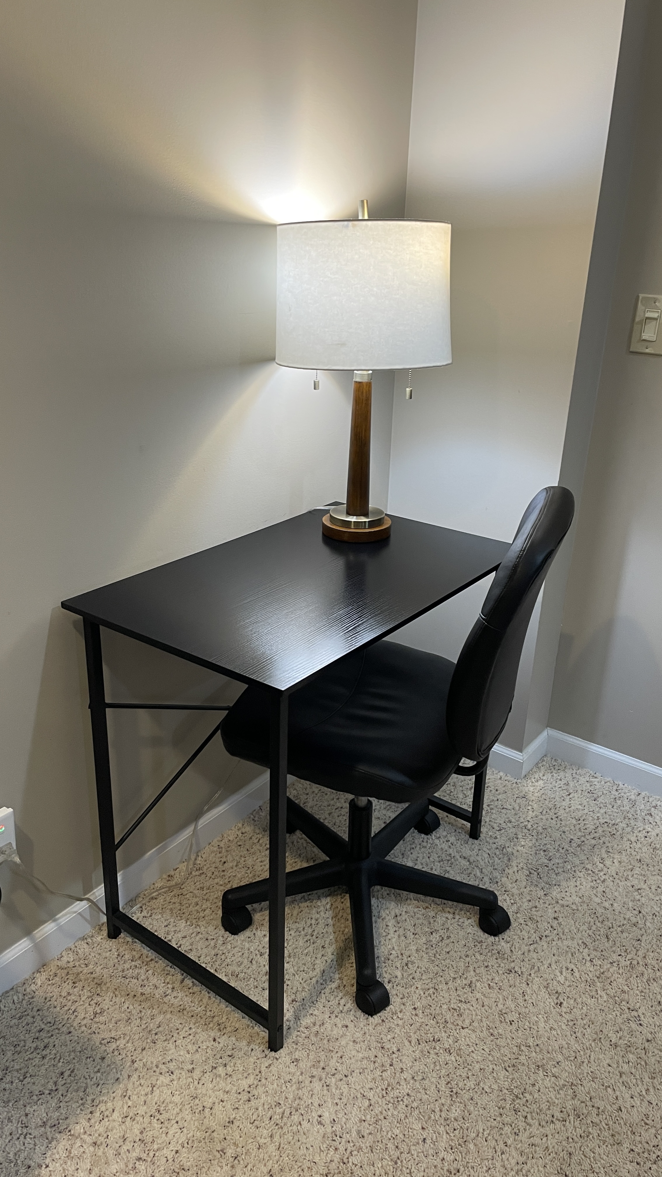 Cozy work nook with desk, rolling chair, and warm lighting