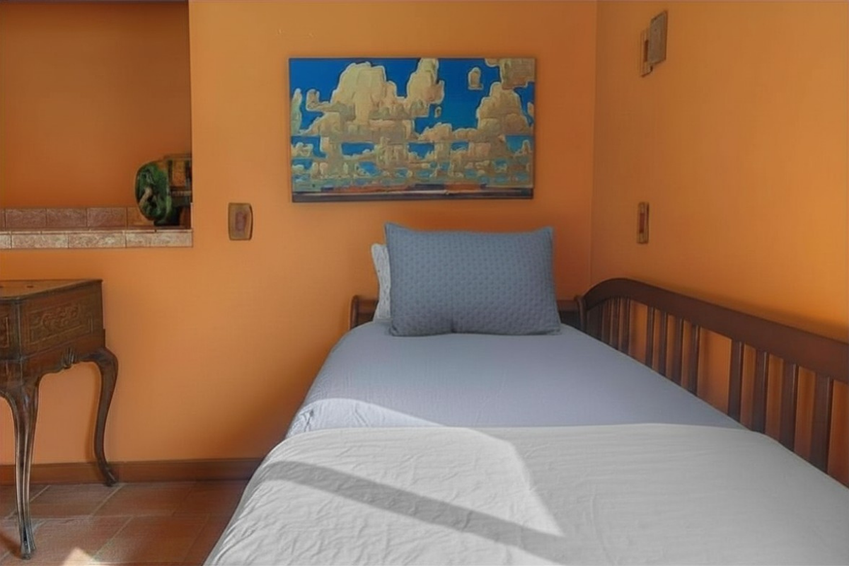 Cozy twin nook with warm hues, art, and tiled alcove—perfect for a peaceful rest
