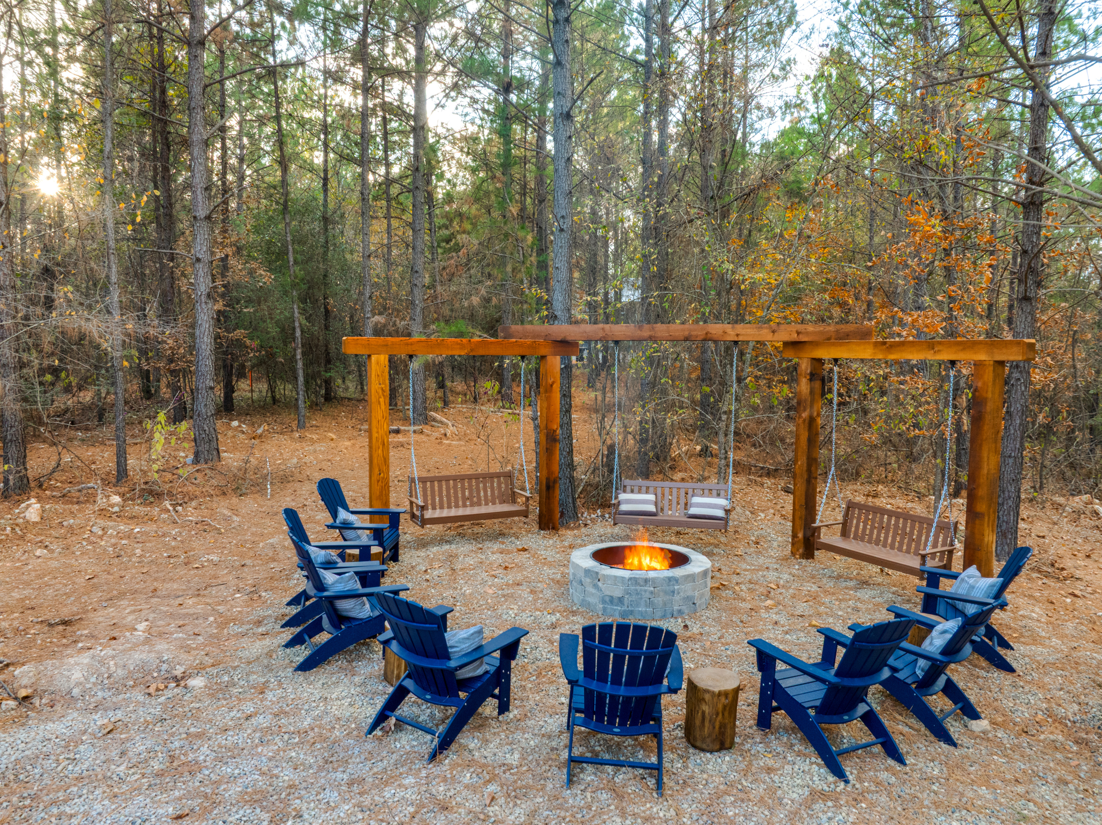 Wooded fire pit lounge with swings for cozy evenings outdoors