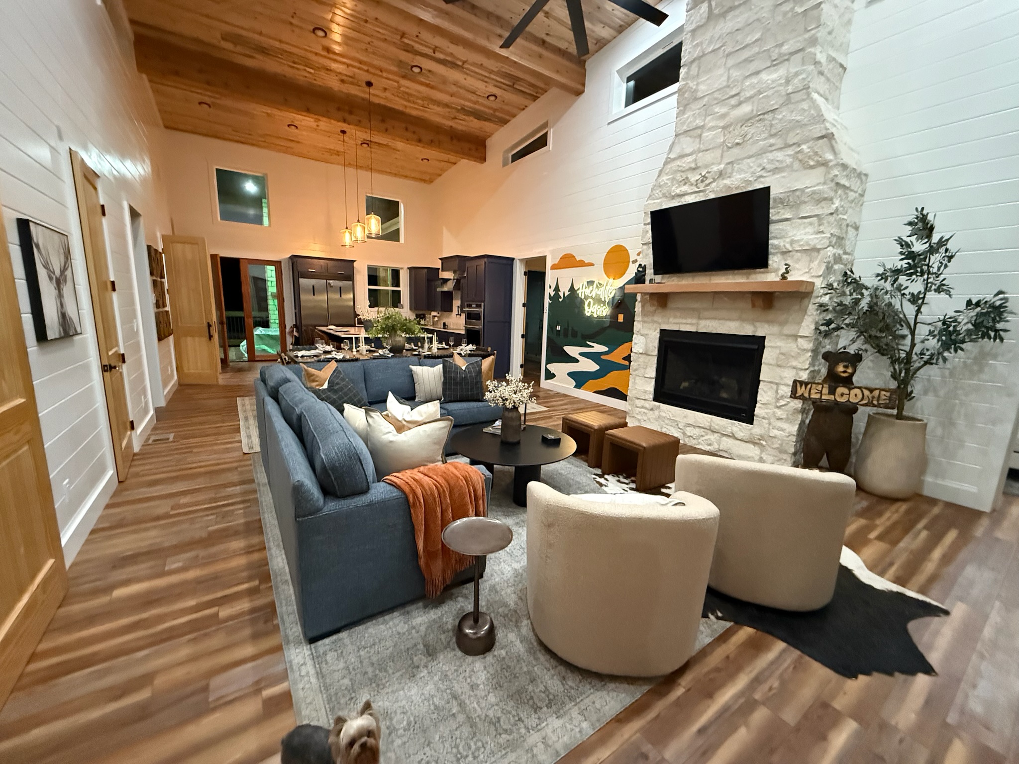 Vaulted great room with stone fireplace, TV, and stylish open living space