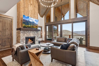 Unwind by the fire in this stunning mountain retreat, where vaulted ceilings, warm wood tones, and floor-to-ceiling windows frame endless Blue Ridge views. Perfect spot to curl up after a day exploring Eagles Nest and Banner Elk.