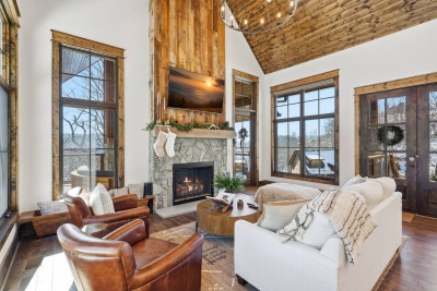 The main living area features vaulted ceilings, a wood-burning fireplace, plush seating, and an open layout perfect for gathering, relaxing, and enjoying time together after a day of mountain adventures.