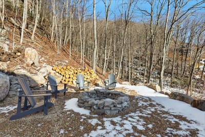 Outdoor fire pit area with seating provides a perfect spot for evening gatherings, roasting marshmallows, or enjoying cool mountain nights surrounded by nature.