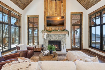 An open-concept living space designed for comfort and connection, featuring ample seating, a fireplace, and easy flow between lounging, dining, and kitchen areas.