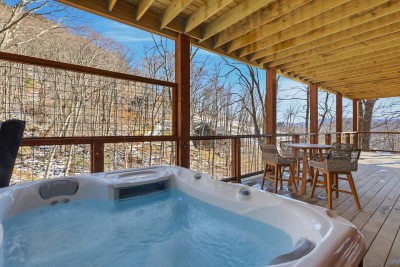 The private hot tub sits on a covered deck, offering year-round relaxation with forest views. Perfect for unwinding after skiing, hiking, or simply enjoying the peaceful mountain setting.