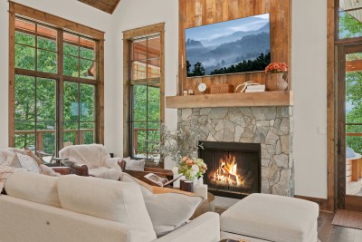 Warm up by the crackling fire beneath a rustic mantel, sink into the leather armchair draped in faux fur, or stretch out on the deep sofa — built for slow mountain evenings.