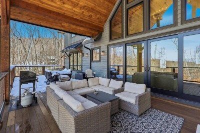 This covered deck is an extension of the living space, designed for year-round enjoyment. With plush outdoor seating, a grill for easy meals, and forest views all around, it’s perfect for slow mornings, cozy evenings, and relaxed gatherings.