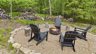 Wooded fire pit retreat with Adirondack seating and rustic charm