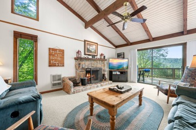 Spacious living room with a wood-burning fireplace, vaulted ceilings, and comfortable seating—perfect for relaxing, movie nights, or fireside conversations.