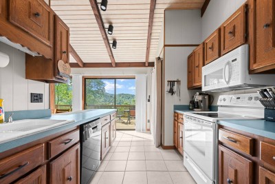 Open-concept kitchen and dining space with full cookware, ample seating, and scenic views—designed for family meals and easy entertaining.