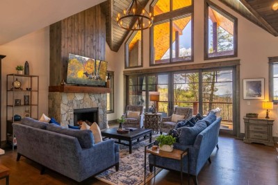 Step into the heart of the home where tall windows frame endless mountain views, the fireplace flickers warmly, and conversations linger long into the night.