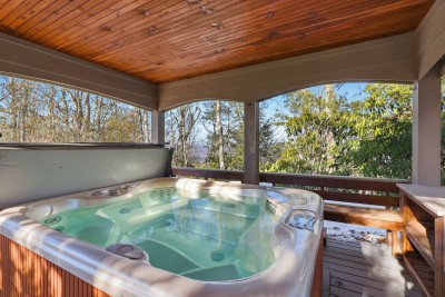 Sink into the covered hot tub while warm water and mountain air work their magic. Protected from the elements, this space lets you relax year-round while soaking in serene forest surroundings.