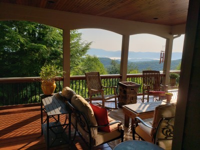 Covered mountain-view deck with cozy seating and stunning scenic vistas