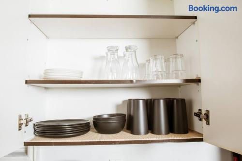 Well-stocked kitchen cabinet with dishes, glasses, and mugs