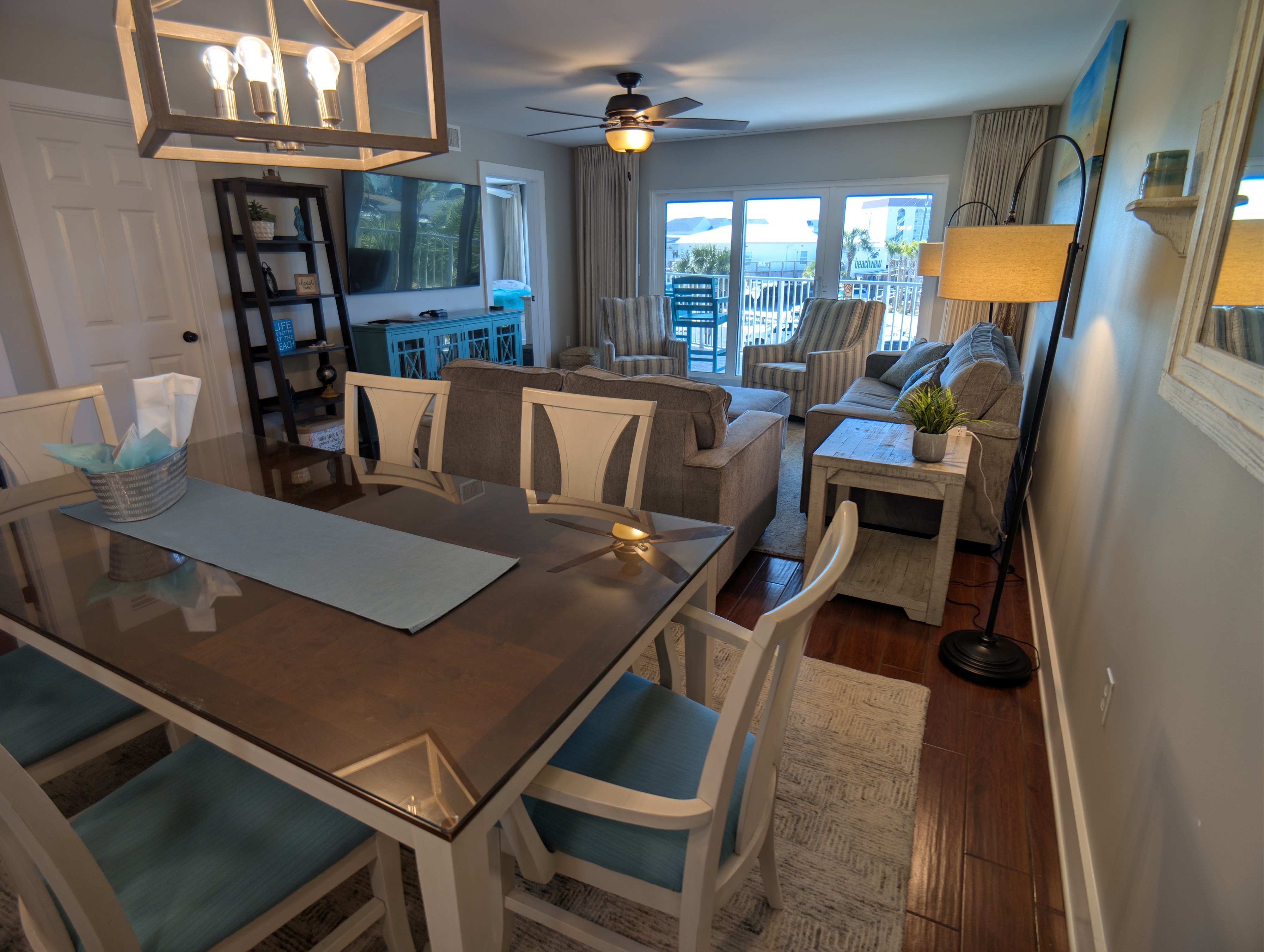 Bright coastal living-dining with balcony and tranquil views.