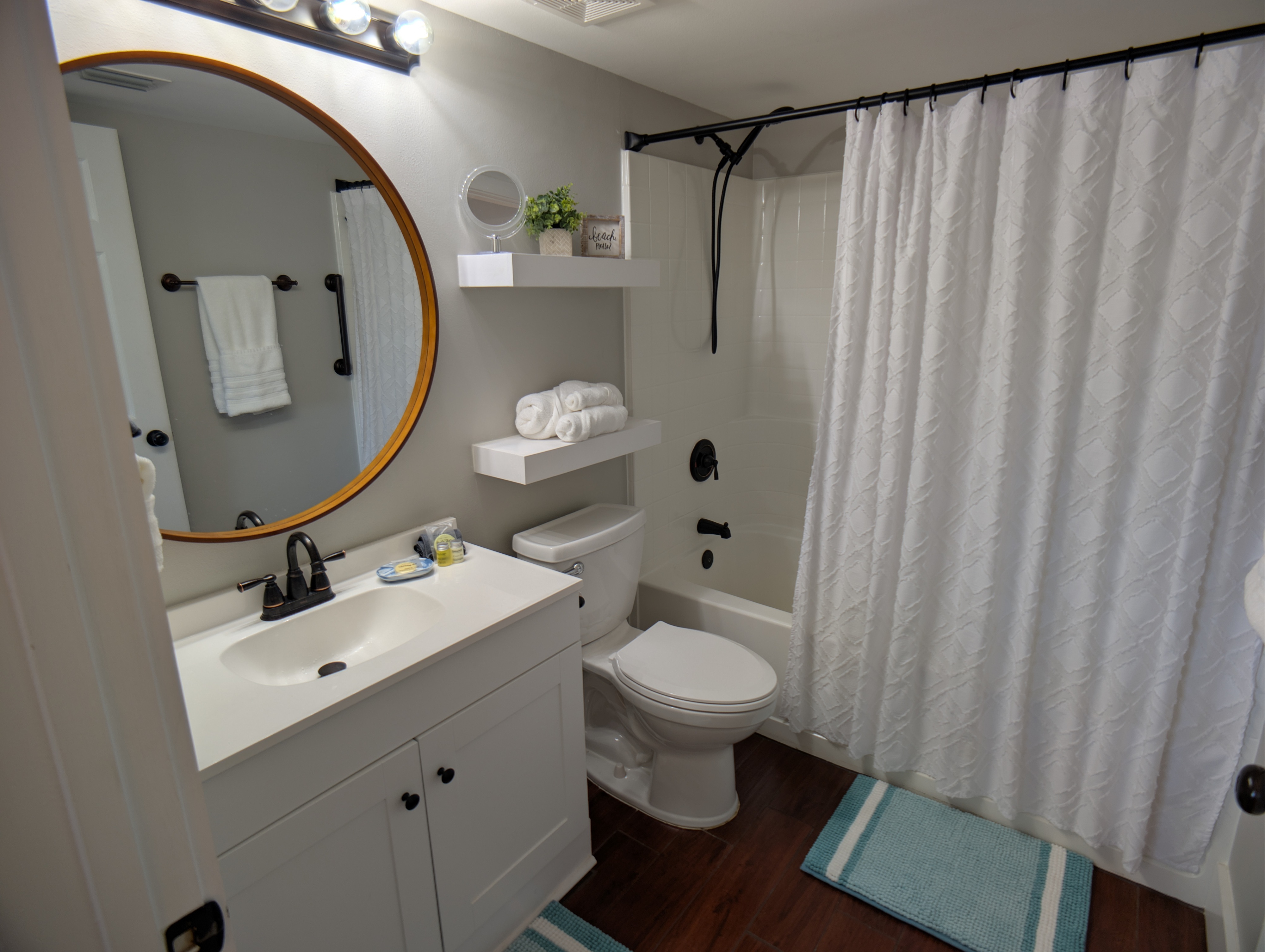 Primary In-suite bathroom with shower tub, soaps, shampoo, and plush towels.