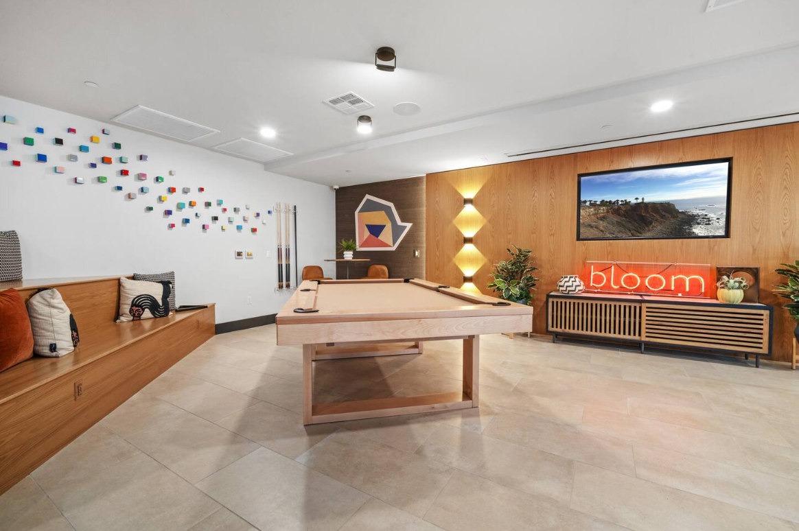 Modern game lounge with pool table, designer lighting, and stylish seating