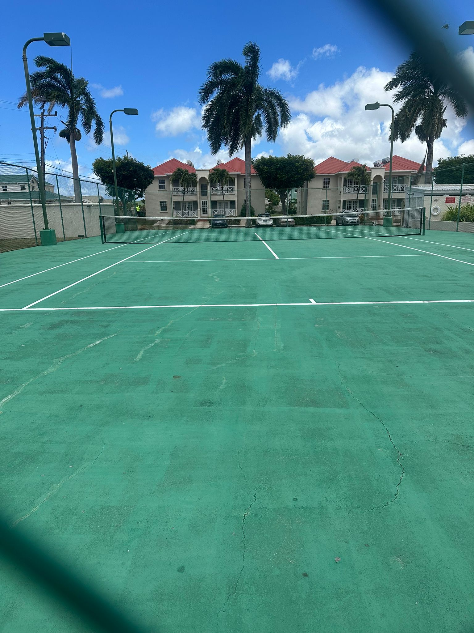 Enjoy sunny matches on the palm-lined on-site tennis court at the gated development Ixora - Crystal Court