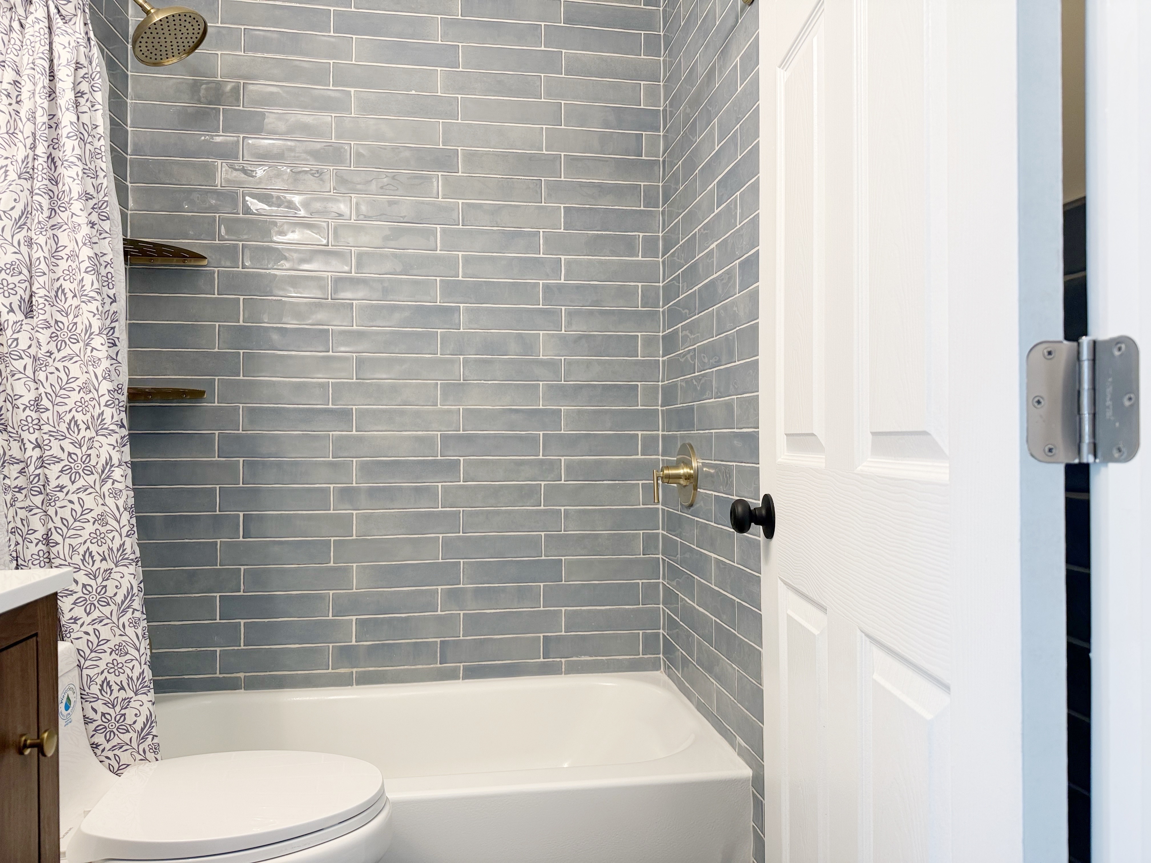 Modern bath with gray tile, rain showerhead, and soaking tub combo