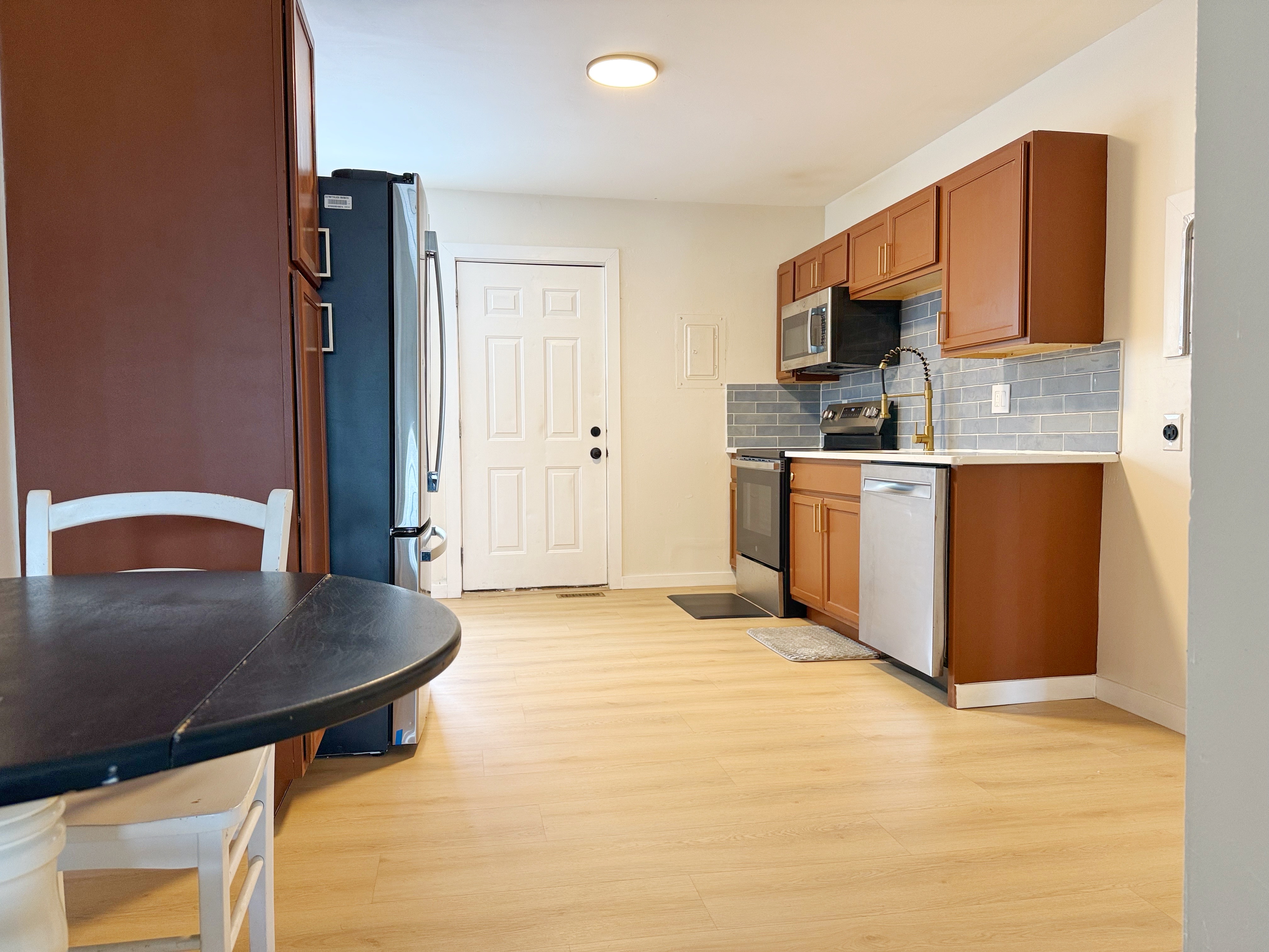Bright kitchen with stainless appliances, subway tile, and dining nook.