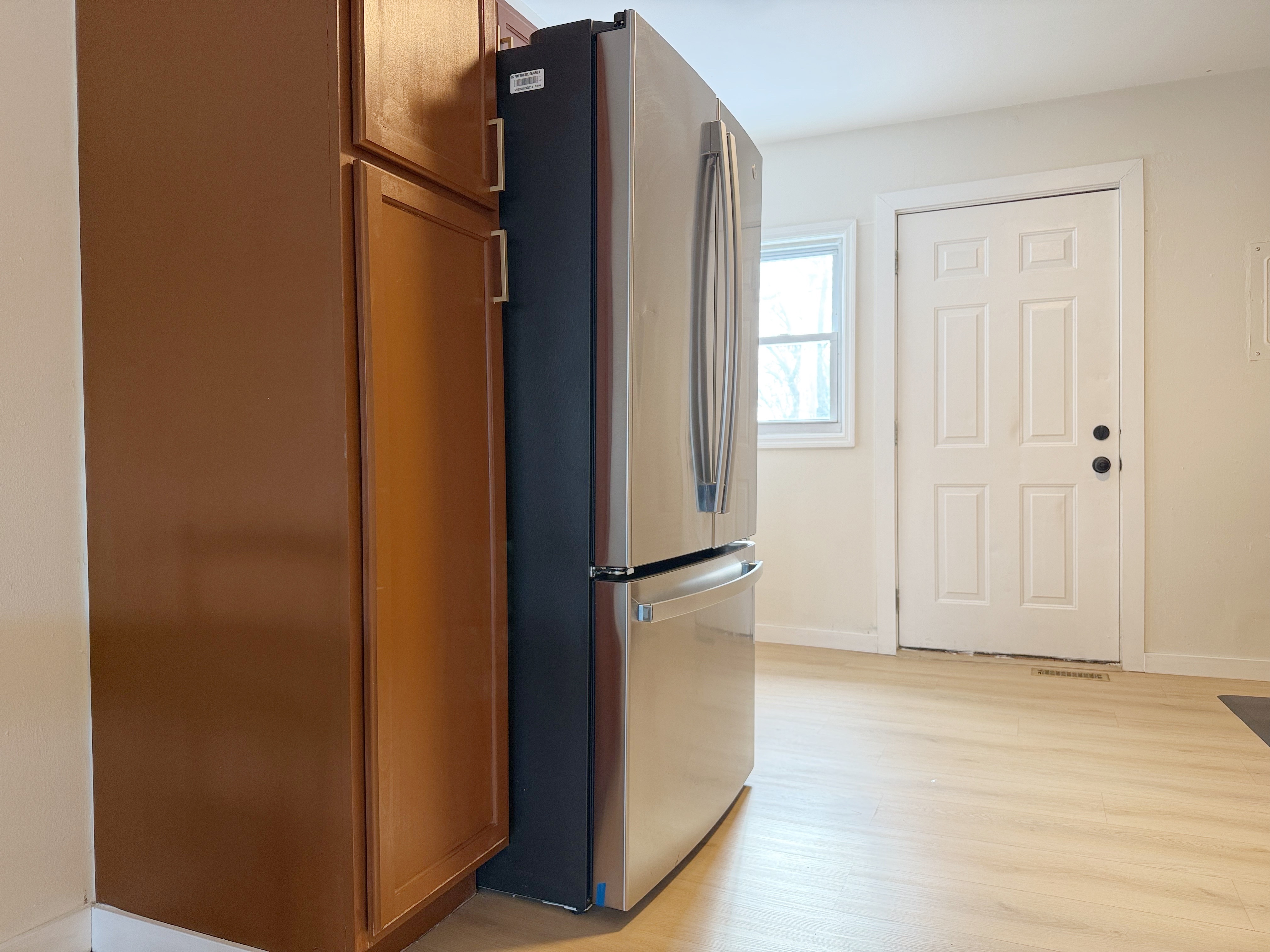 Bright kitchen with stainless French-door fridge and natural light.