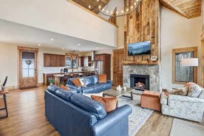 Gather around the stone fireplace in this bright, open living room with soaring ceilings and warm wood accents. It’s the perfect space for movie nights, morning coffee, or relaxing together after a day outside.