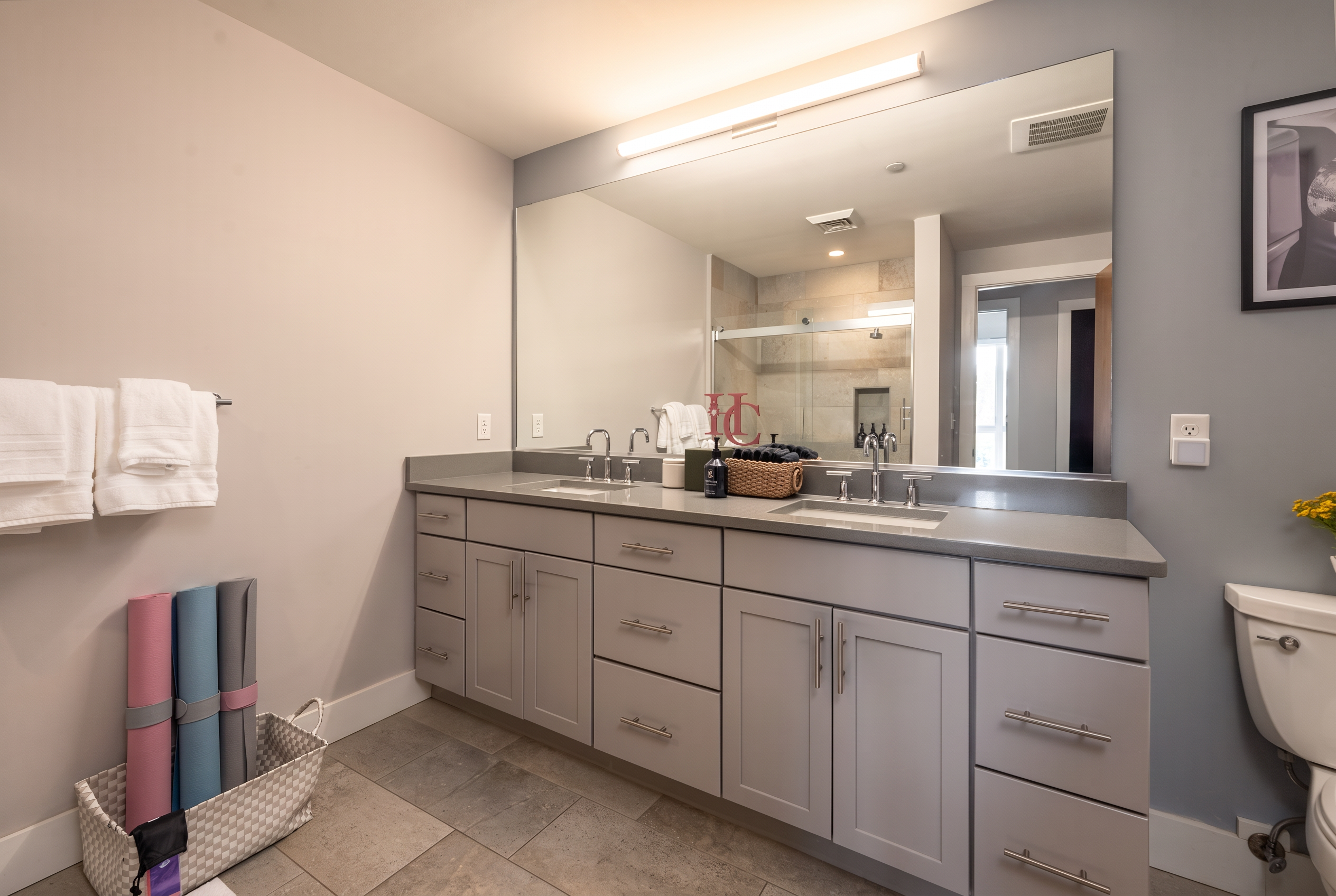 Bright modern bathroom with double vanity, large mirror, and sleek finishes