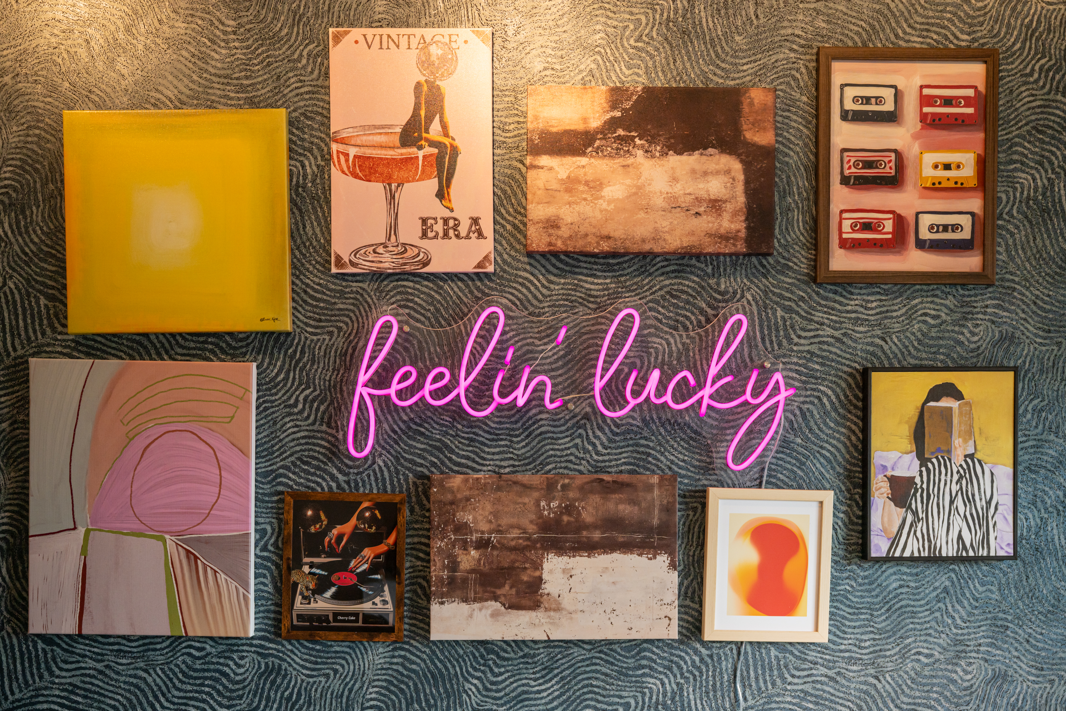 Eclectic gallery wall with neon sign and bold, playful vintage vibes...Make yourself right at home!