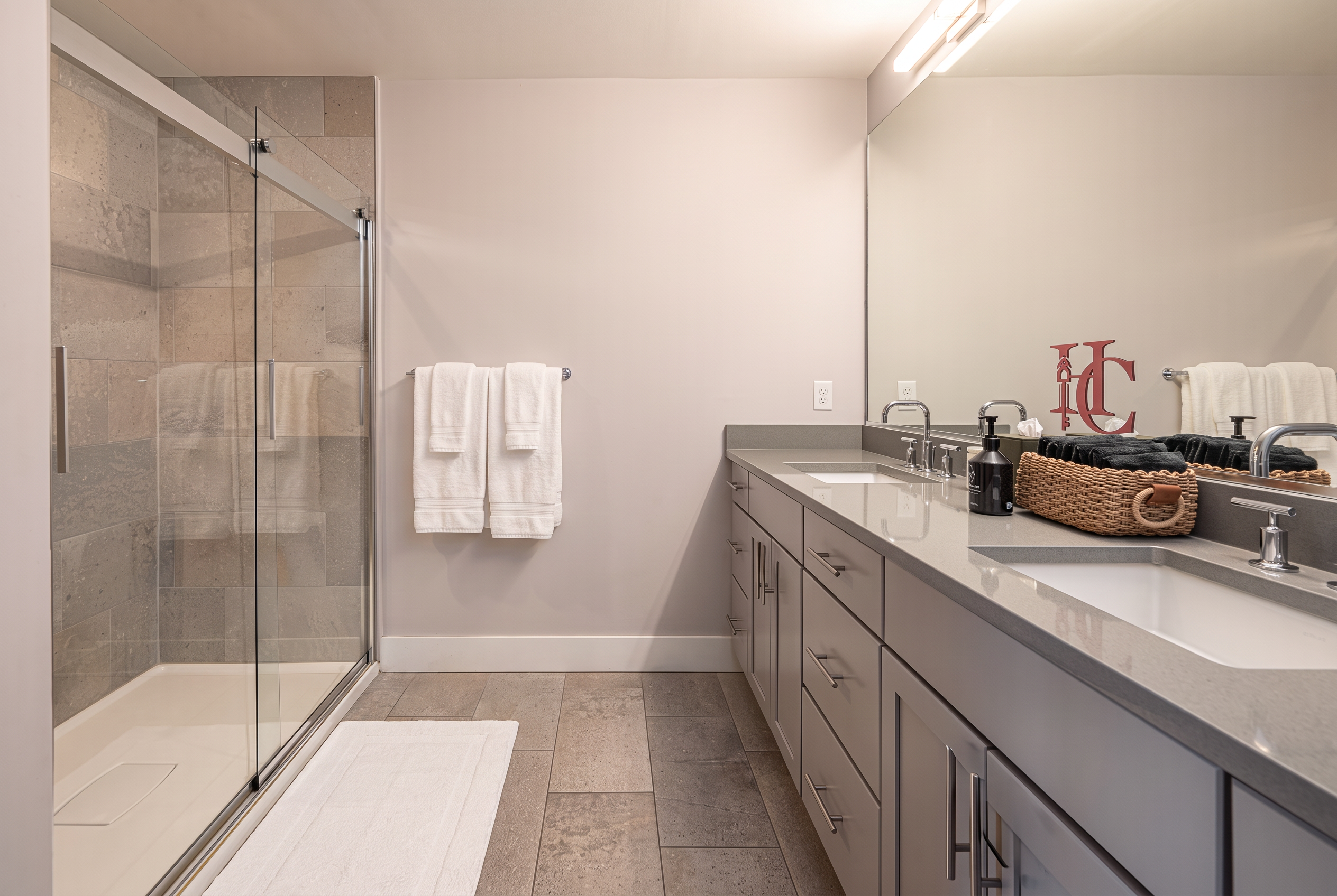 Bright spa-style bathroom with double vanity and glass walk-in shower