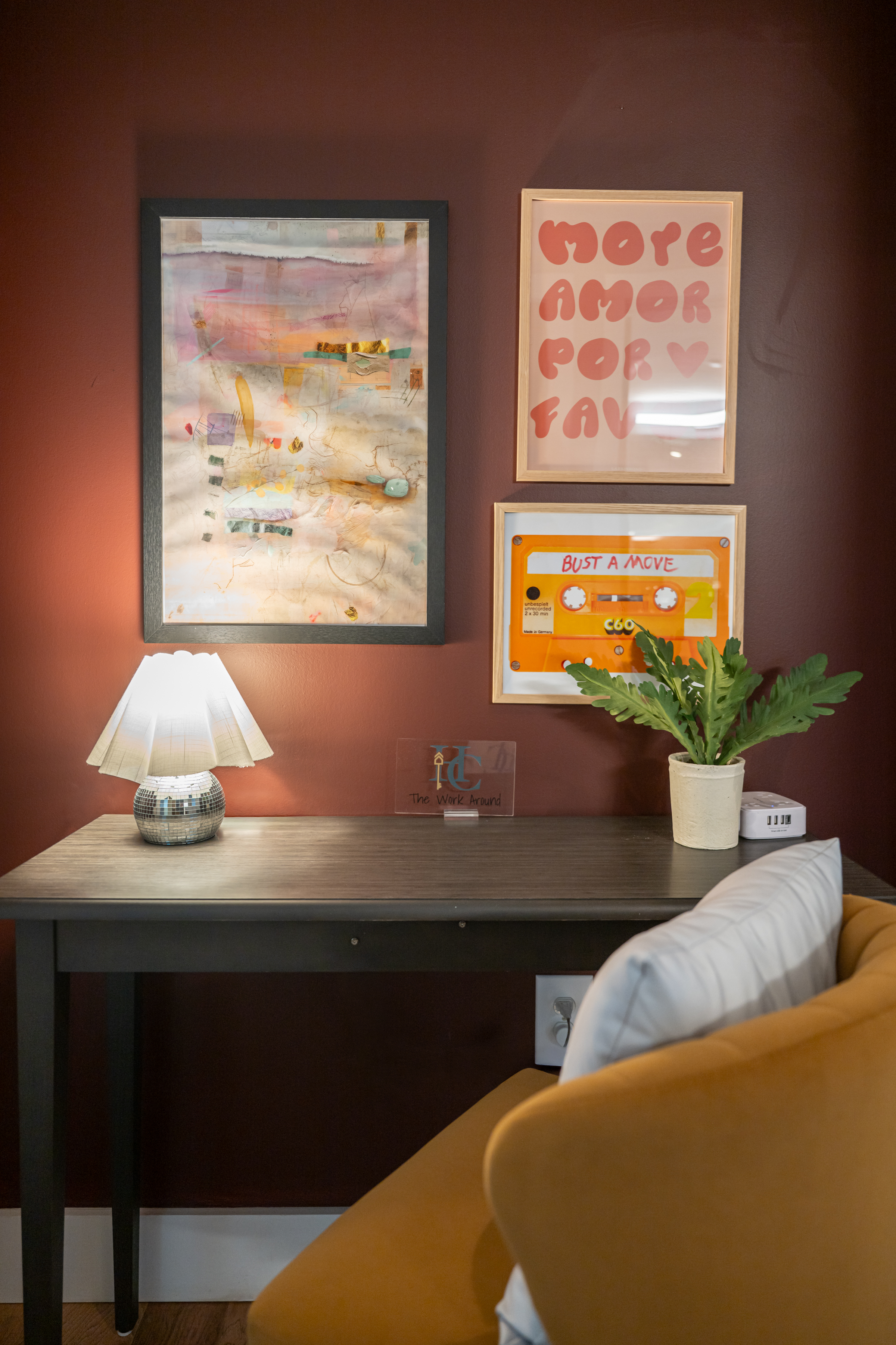 Chic workspace nook with warm lighting, bold art, and a comfy accent chair