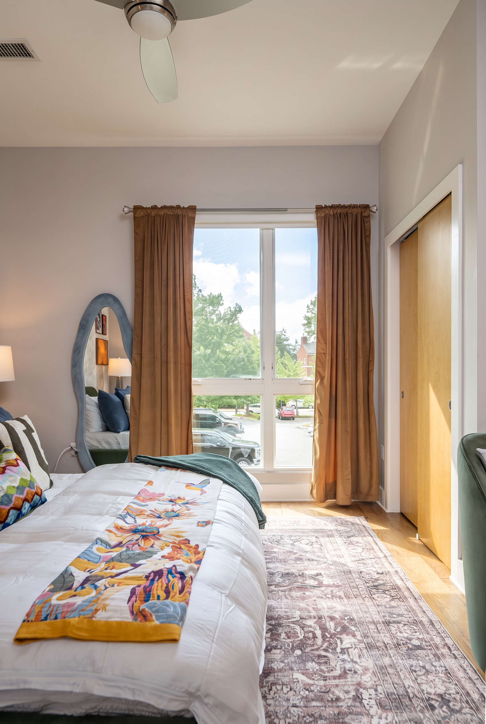 Bright, stylish bedroom with oversized window and cozy designer touches
