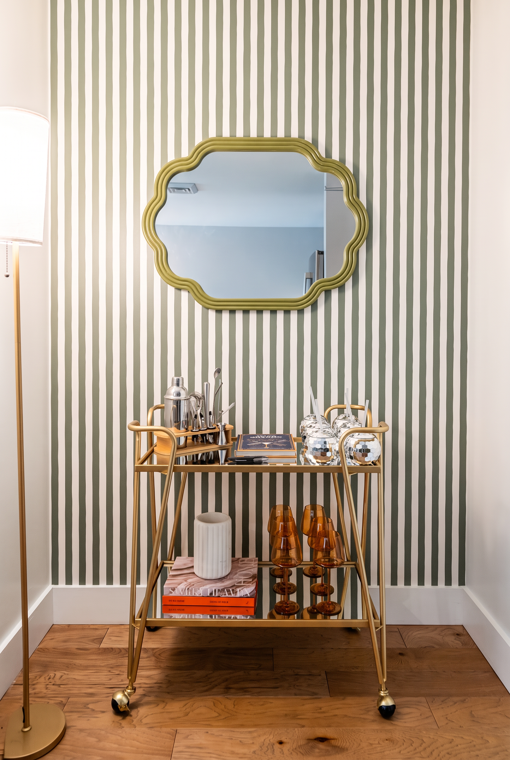 Chic bar cart nook with striped wallpaper, gold accents, and boutique-style flair