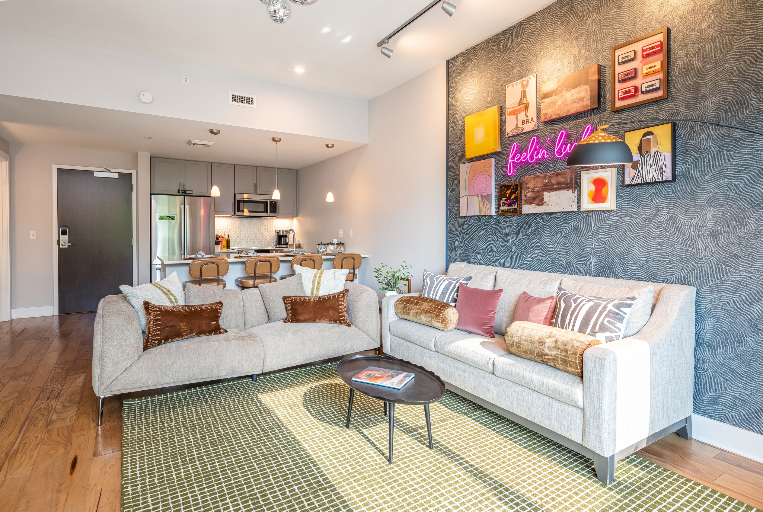 Stylish open living room with designer accent wall and sleek kitchen bar