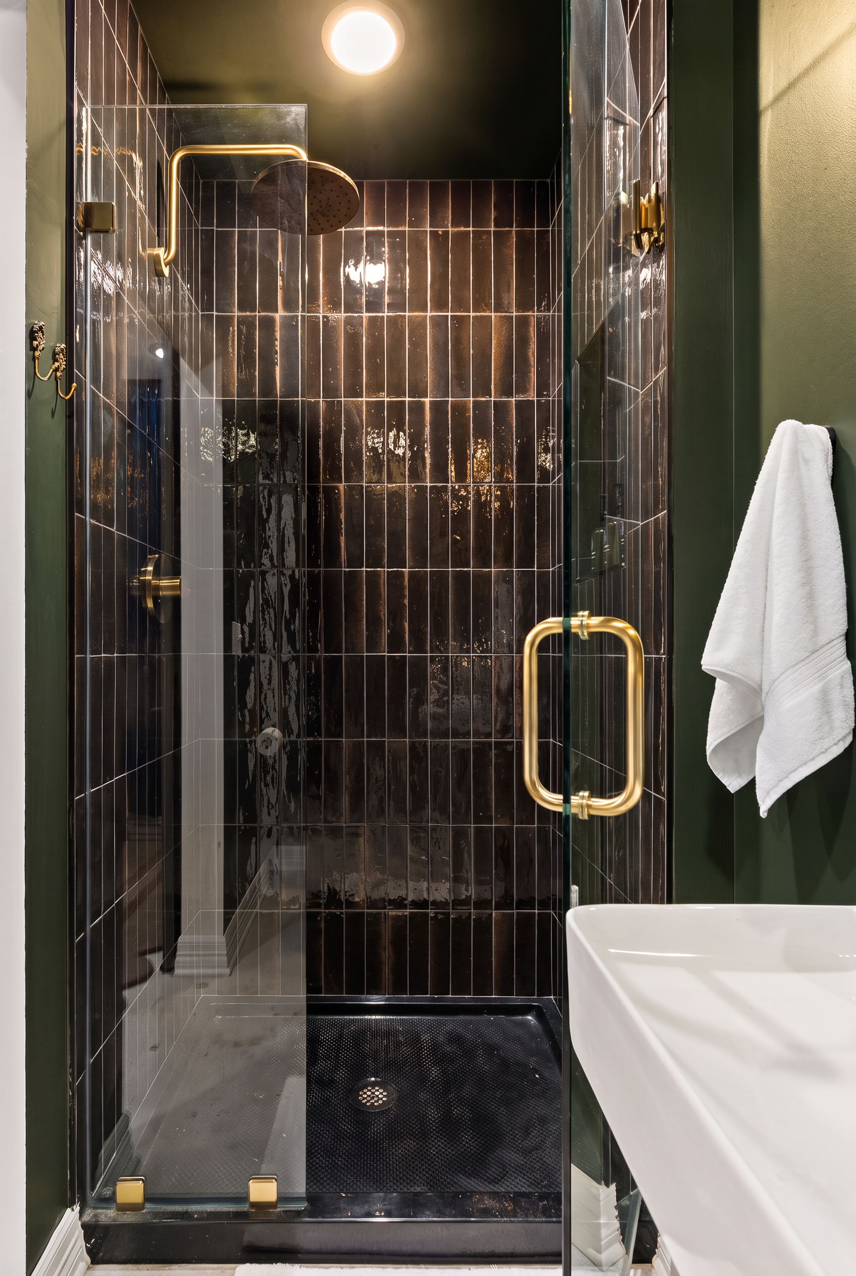 Moody luxe bathroom with glass shower and elegant brass accents