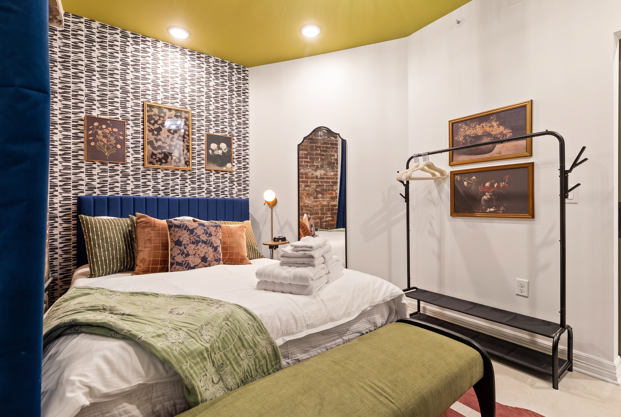 Boutique-style bedroom with bold decor, cozy linens, and thoughtful touches
